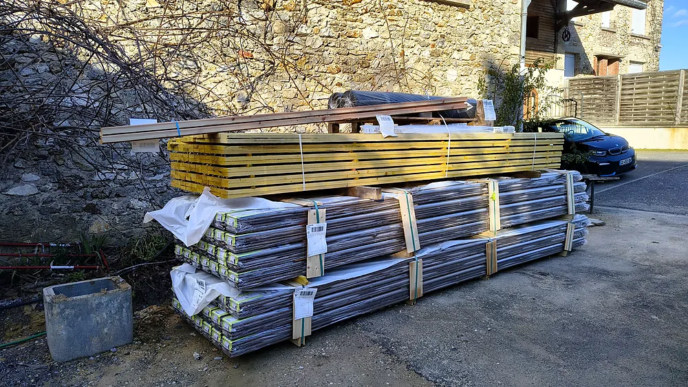 Bois de charpente et isolants livrés sur le chantier avant pose
